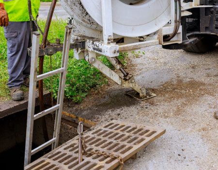 Sewage cleaning workers equipment with sewer on a town street on industrial truck